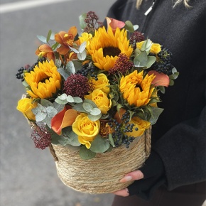 Композиция в сумке "Тональность" из подсолнухов, калл, ягод вибирнума, лимонных роз, скиммии и орхидеи в Хотьково